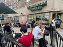 Les gens se pressent autour d'un café Starbucks pour utiliser son wifi gratuit sur le réseau Bell, lors d'une panne majeure des réseaux mobiles et Internet de Rogers Communications à Toronto, le 8 juillet 2022. 