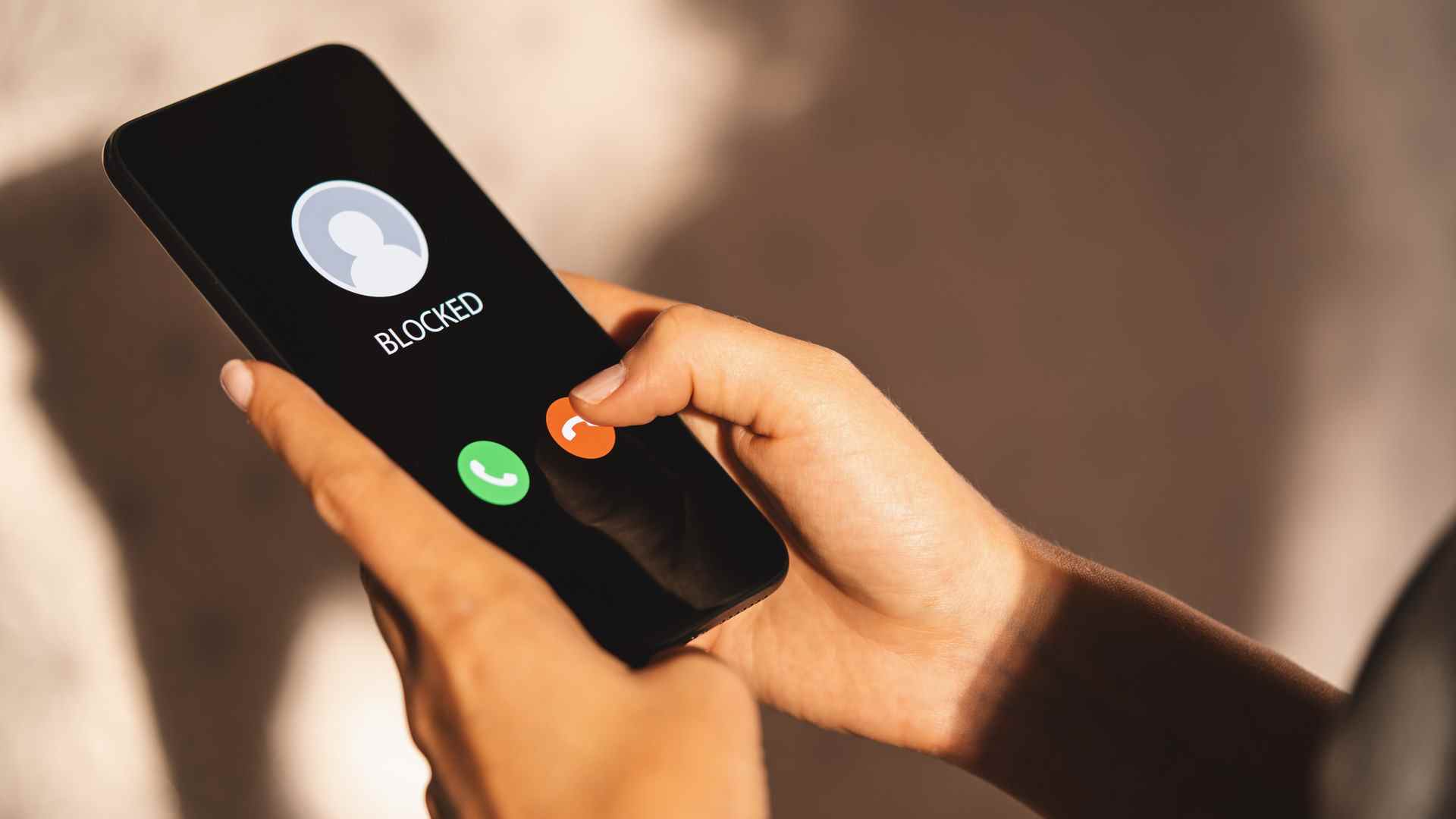 Smartphone tenu dans les mains de la personne affichant Bloqué sur l'écran des appels entrants