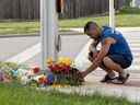 Un homme apporte des fleurs et présente ses respects sur les lieux où un homme conduisant une camionnette a heurté et tué quatre membres d'une famille musulmane à London, en Ontario, le 7 juin 2021.