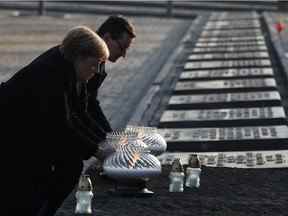 Le Premier ministre polonais Mateusz Morawiecki et la chancelière allemande Angela Merkel placent des bougies au Monument aux victimes de l'ancien camp de concentration et d'extermination nazi d'Auschwitz II-Birkenau près d'Oswiecim, en Pologne, le 6 décembre 2019.