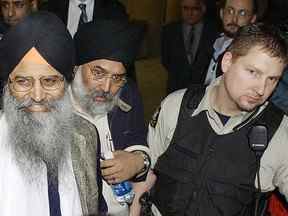 16 mars 2005. Le juge du procès pour attentat à la bombe d'Air India a déclaré Ripudaman Singh Malik (à gauche) non coupable de l'attentat à la bombe contre le vol 182 d'Air India. Il est escorté par un shérif du tribunal et un homme non identifié jusqu'à une voiture en attente.