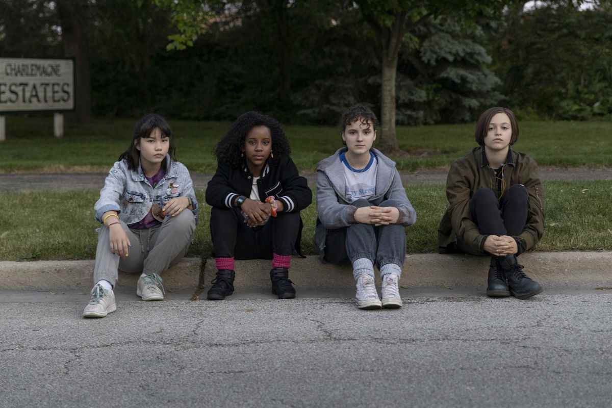 Les quatre Paper Girls assises sur un trottoir