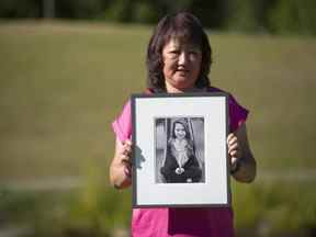 Carol Todd tient une photo de sa fille Amanda Todd, la jeune de 15 ans qui s'est suicidée en octobre 2012 après avoir été victime d'intimidation, au Settlers Park de Port Coquitlam le 18 août 2020.