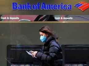 Une personne passe devant un panneau Bank of America dans le quartier de Manhattan à New York.