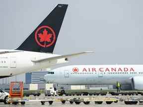 Des avions d'Air Canada sont assis sur le tarmac de l'aéroport international Pearson pendant la pandémie de COVID-19 à Toronto, le 28 avril 2021.