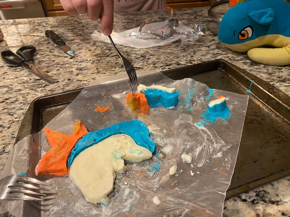 Une plaque à pâtisserie avec trois sucettes glacées, toutes en forme de Pokémon Cyndaquil, un allume-feu.