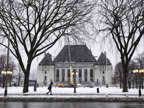 Un piéton passe devant la Cour suprême du Canada à Ottawa le jeudi 26 novembre 2020. Le plus haut tribunal du Canada a confirmé à l'unanimité la condamnation pour meurtre au premier degré d'un homme reconnu coupable d'un meurtre en janvier 2015 près de Prince George, en Colombie-Britannique.