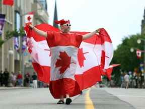 Un homme portant des drapeaux canadiens défile lors des célébrations de la fête du Canada le 1er juillet 2022 à Ottawa, au Canada.