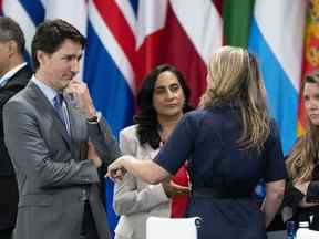 Le premier ministre Justin Trudeau et la ministre de la Défense Anita Annad écoutent la ministre des Affaires étrangères Melanie Joly avant la séance d'ouverture du sommet de l'OTAN à Madrid le mercredi 29 juin 2022.