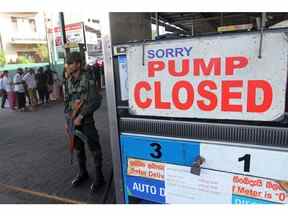 Un membre du personnel de sécurité sri-lankais monte la garde devant une station-service en panne d'essence à Colombo le 27 juin 2022. Photographe : -/AFP/Getty Images