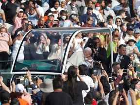 Le pape François embrasse un bébé avant de célébrer une messe au stade du Commonwealth lors de sa visite à Edmonton, Alberta, Canada le 26 juillet 2022.