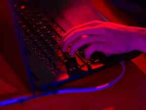 La lumière rouge illumine les touches d'un ordinateur portable.  Photographe : Andrey Rudakov/Bloomberg