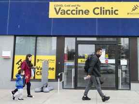 Des gens passent devant une clinique de vaccination pendant la pandémie de COVID-19 à Mississauga le 13 avril 2022.
