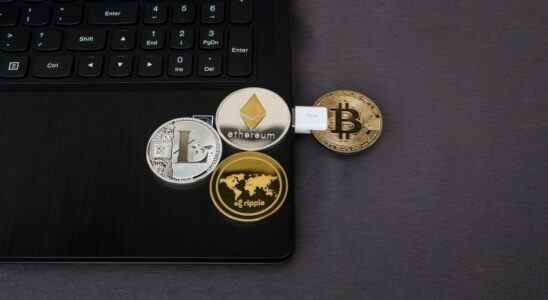 Image of pretend cryptocurrency coins on laptop and plugged in via USB