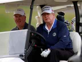 Le président américain Donald Trump conduit une voiturette de golf au Trump National Golf Club à Sterling, en Virginie, le 22 novembre 2020.