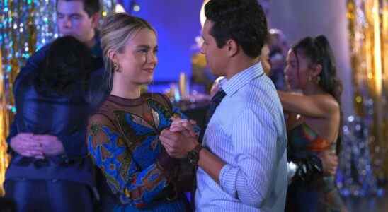 A blonde woman with pulled back hair and a blue and red butterfly-patterned dress dances with a man in a light blue collared shirt in a high school gym; still from "Maggie."