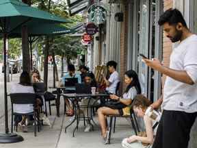 Le comité de l'industrie de la Chambre des communes tiendra deux audiences aujourd'hui au sujet de la panne de Rogers qui a duré plus de 15 heures et laissé des millions de Canadiens dans une panne de communication.  Les gens utilisent le Wi-Fi fourni par Starbucks dans un magasin de Toronto au milieu d'une panne nationale de Rogers, affectant de nombreux services de la société de télécommunications, le vendredi 8 juillet 2022.