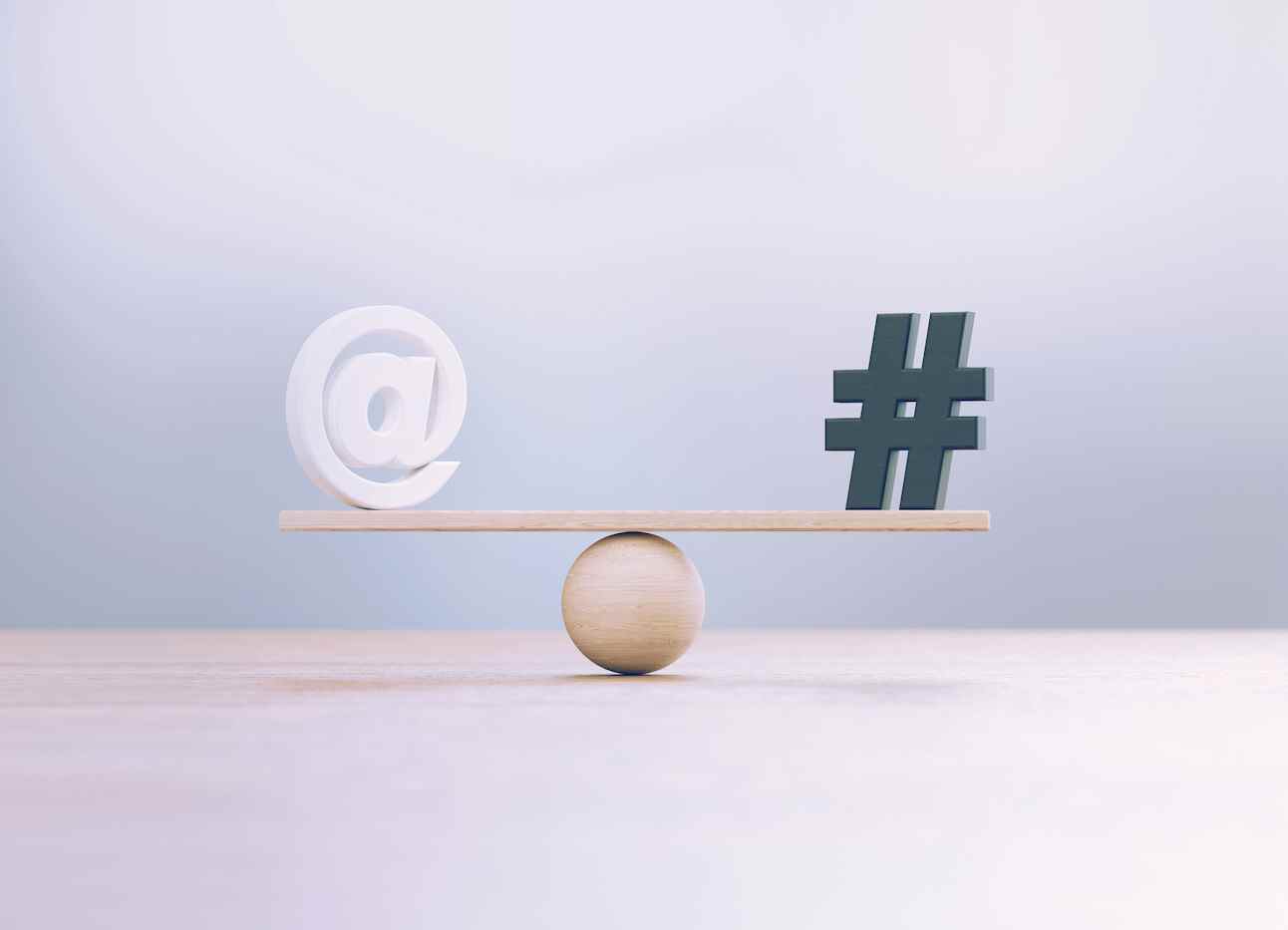 Symboles de hashtag blanc et noir assis sur une échelle de balançoire en bois avant un arrière-plan défocalisé.