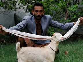 Mohammad Hassan Narejo, 30 ans, montre Simba, un chevreau d'un mois et quatre jours avec des oreilles de 48 cm de long, chez lui à Karachi, au Pakistan, le 8 juillet 2022.
