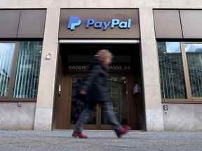 Un piéton passe devant le logo PayPal dans un immeuble de bureaux à Berlin, en Allemagne.