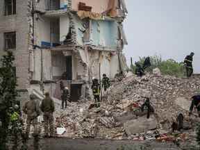 Des sauveteurs travaillent dans un immeuble résidentiel endommagé par une frappe militaire russe dans la ville de Chasiv Yar, dans la région de Donetsk, en Ukraine, le 11 juillet 2022.