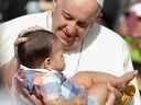 Le pape François bénit un bébé alors qu'il arrive pour présider une messe au Commonwealth Stadium à Edmonton, Alberta, Canada le 26 juillet 2022. REUTERS/Amber Bracken