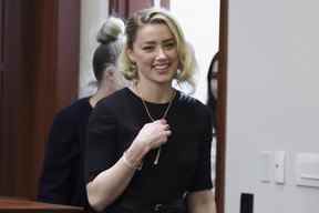 Amber Heard sourit en arrivant avant l'annonce du verdict du jury au palais de justice du comté de Fairfax à Fairfax, en Virginie, le mercredi 1er juin 2022.