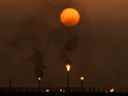 Le soleil se couche alors que des torchères brûlent l'excès de gaz dans un champ pétrolifère irakien.