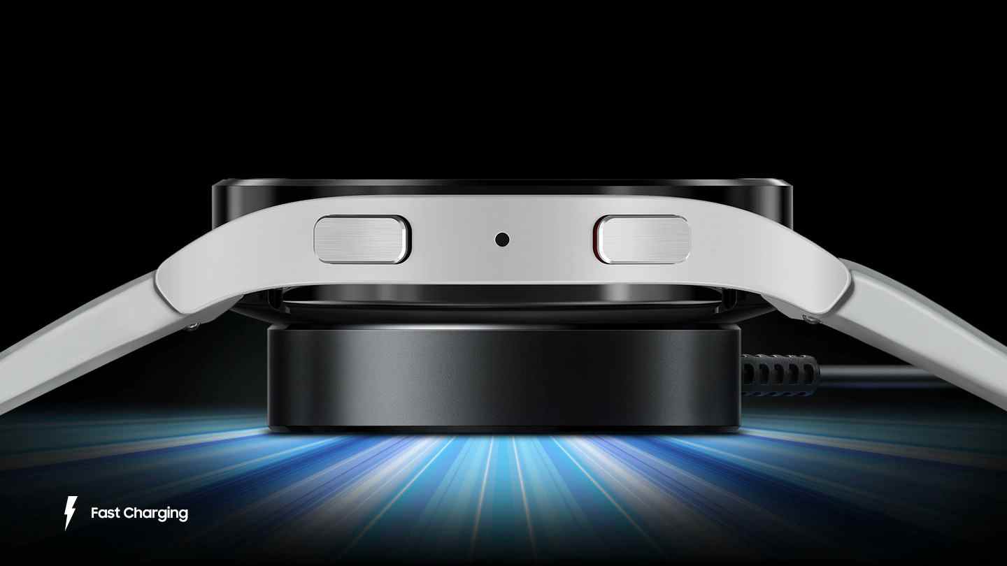 Un rendu montrant une smartwatch Samsung en charge sur un chargeur sans fil.  Le texte 