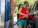 Un client pompe de l'essence dans une station-service au Texas.  Les prix de l'essence ont chuté en juillet.