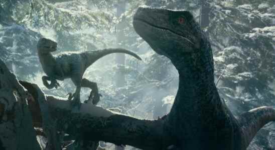 Blue and her baby together in the snowy woods in Jurassic World: Dominion.