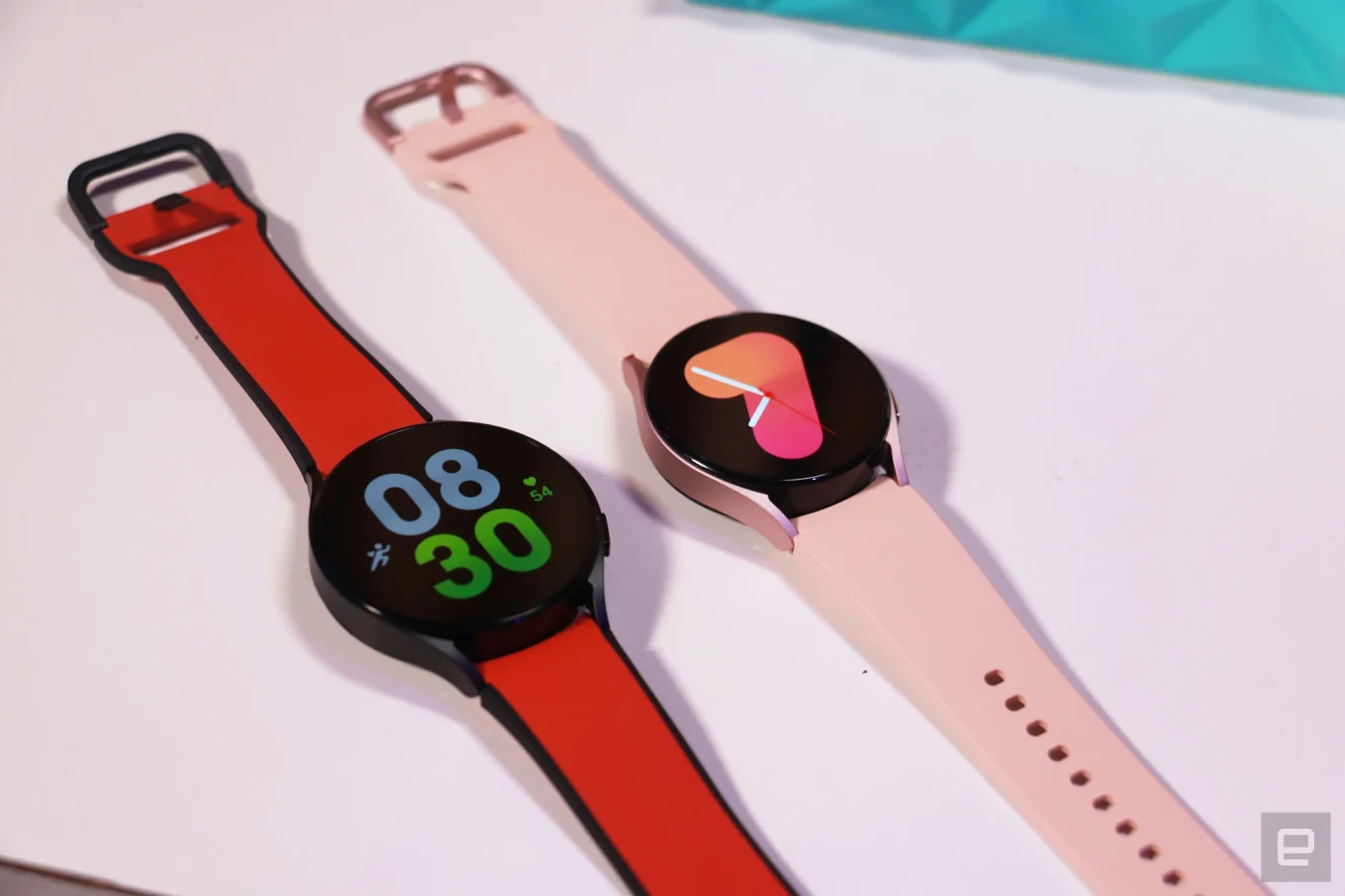 Une Galaxy Watch 5 rouge de 44 mm et une Galaxy Watch 5 rose de 40 mm côte à côte sur une table.