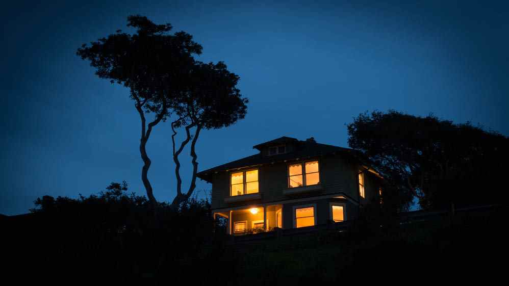 Une maison avec toutes ses lumières allumées la nuit