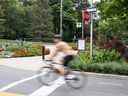 Un cycliste traverse une intersection sans s'arrêter à High Park à Toronto, en Ontario.  le jeudi 4 août 2022.