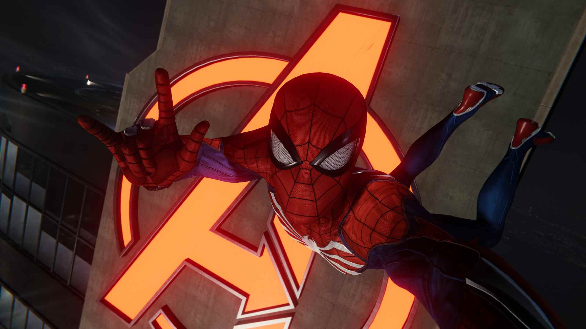 Revue PC remasterisée de Spider-Man de Marvel : Un selfie de Spidey, nous donnant les cornes avec sa main droite, contre la lueur néon de la tour Avengers