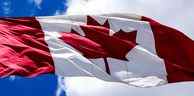 Drapeau du Canada agitant sur un ciel bleu.