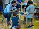 Le premier ministre Justin Trudeau rend visite aux enfants d'une garderie à St. John's, T.-N.-L., en juillet.  La province a conclu une entente avec Ottawa pour un programme de garde d'enfants à 10 $ par jour.