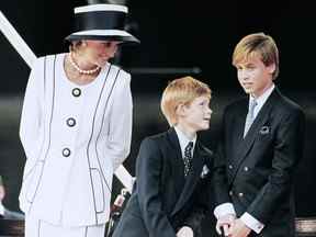 Dans cette photo d'archive prise le 19 août 1995, la princesse Diana et leurs enfants William et Harry regardent le défilé sur une estrade du centre commercial dans le cadre des commémorations du VJ Day.
