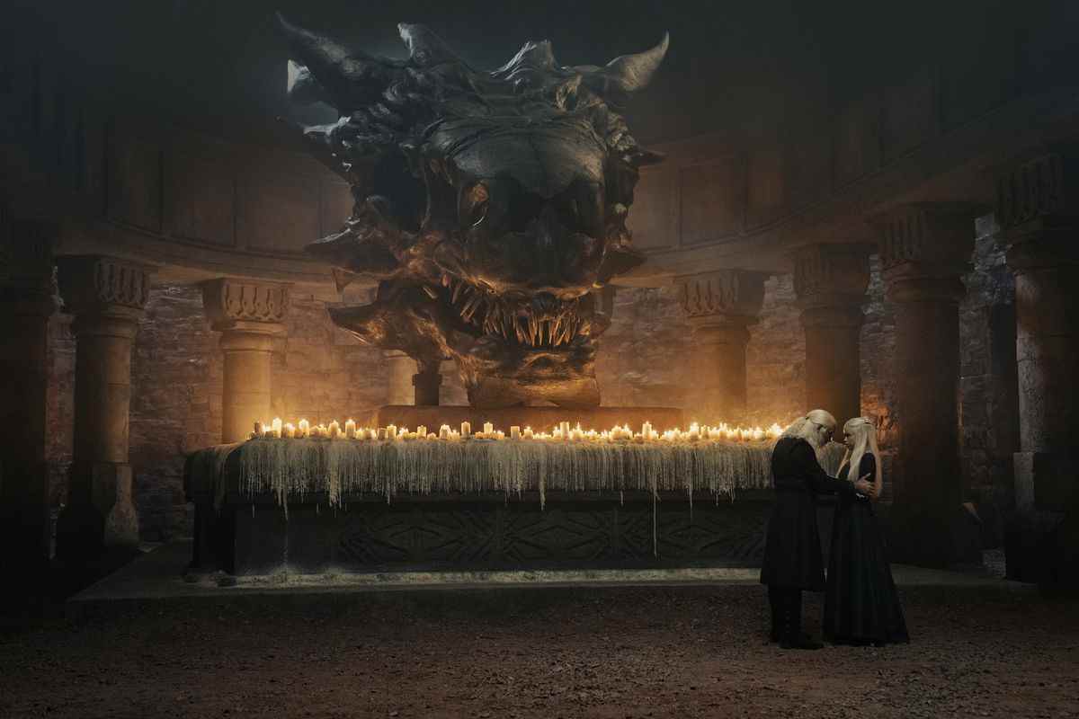 Viserys parle à sa fille devant un autel avec un bouquet de bougies et un crâne de dragon géant dans House of the Dragon