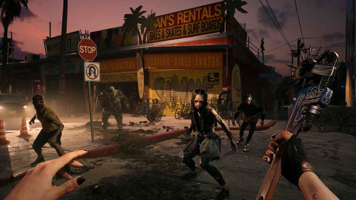 Une vue à la première personne du joueur, tenant une clé personnalisée, face à des zombies attaquants dans une rue sombre