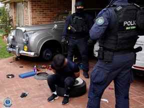 Les photographies de la police du raid montrent les lignes distinctives d'une Bentley argentée métallique dans l'allée d'une maison, sous un abri de voiture ouvert.