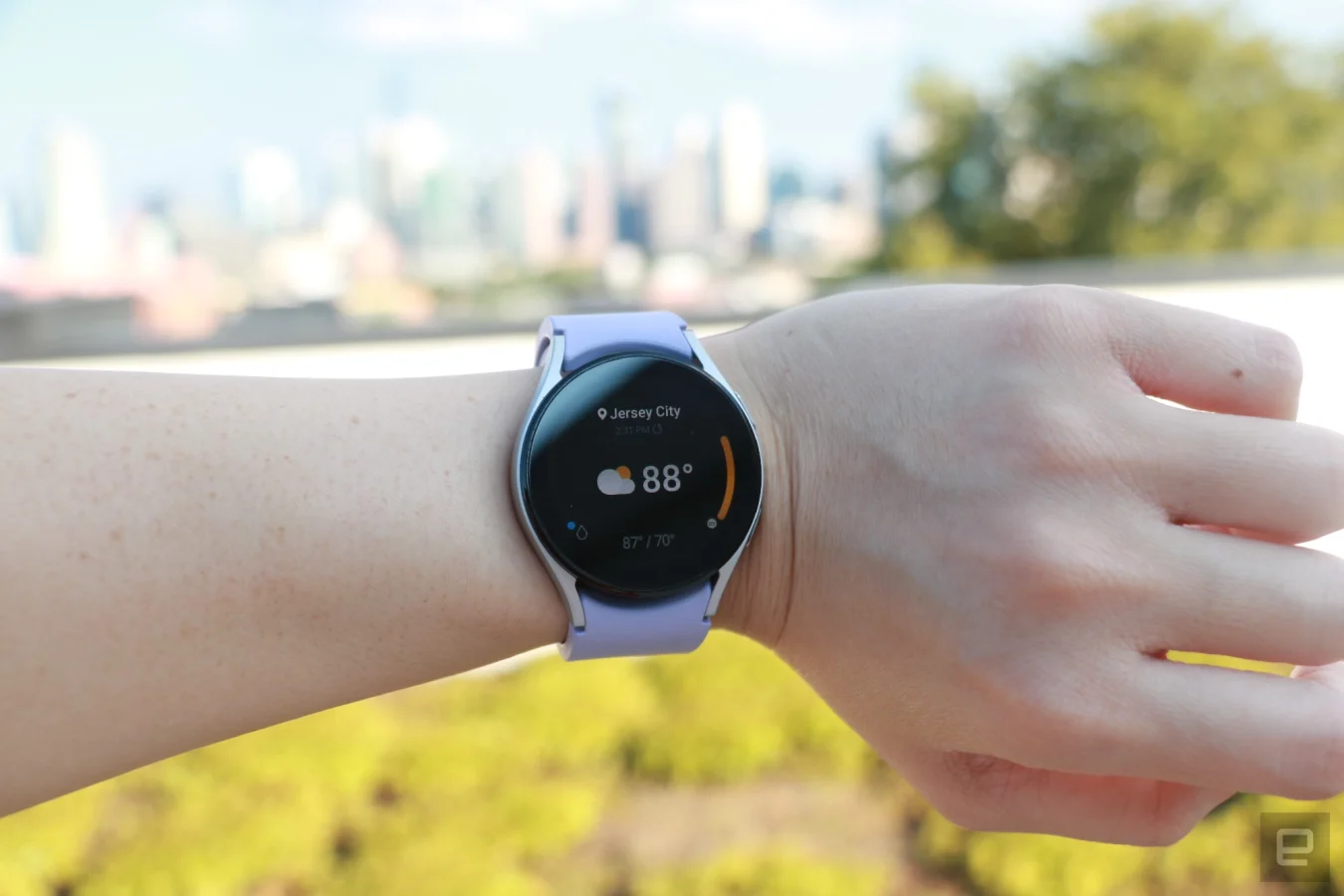 La Samsung Galaxy Watch 5 au poignet, affichant l'application météo.  Il indique Jersey City en haut, suivi de 88 degrés dans une police plus grande occupant la majorité de la page, et d'un nuage avec une icône de soleil sur sa gauche.