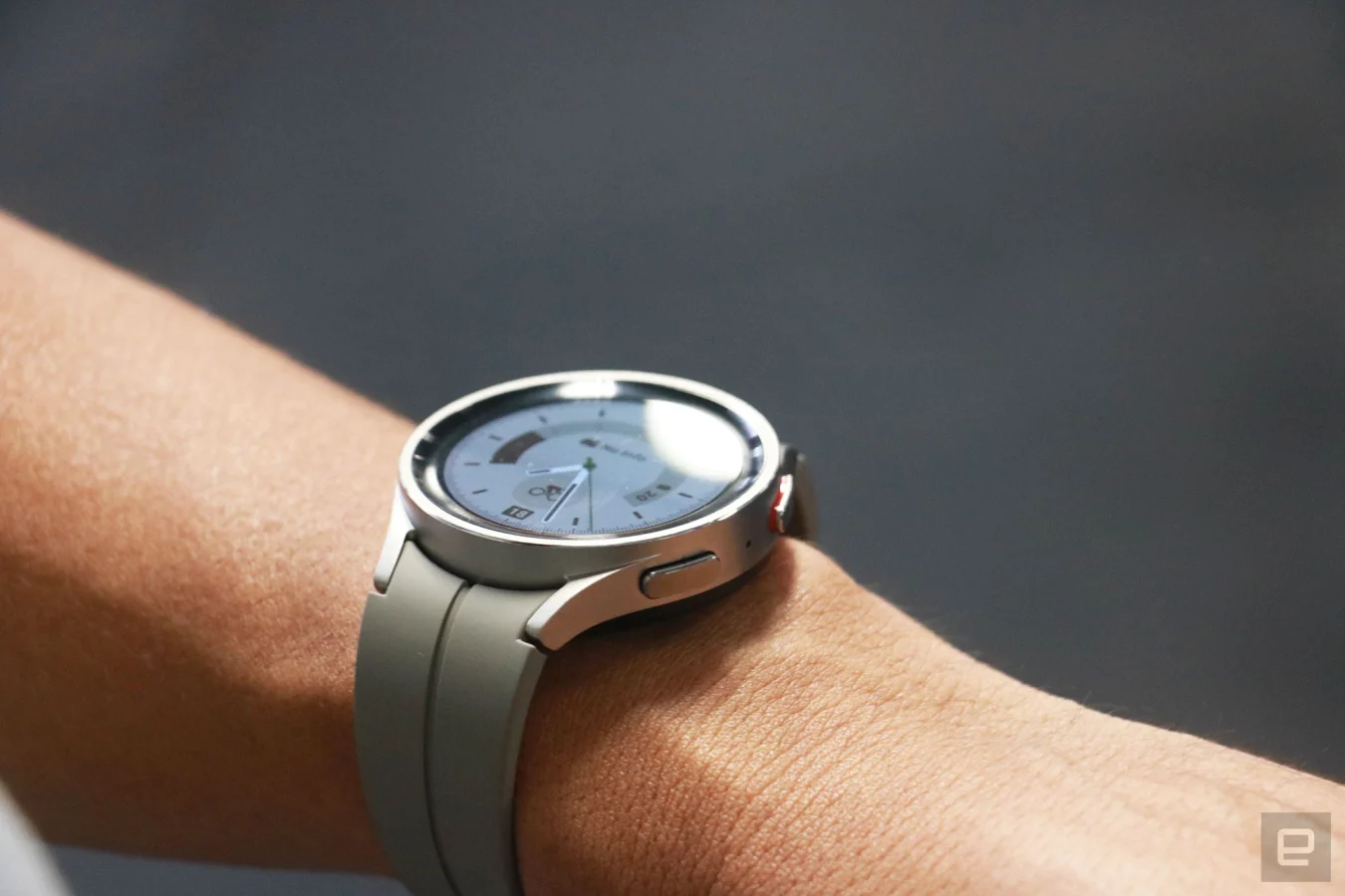 La Samsung Galaxy Watch 5 Pro au poignet, avec quelques lumières se reflétant sur son écran.
