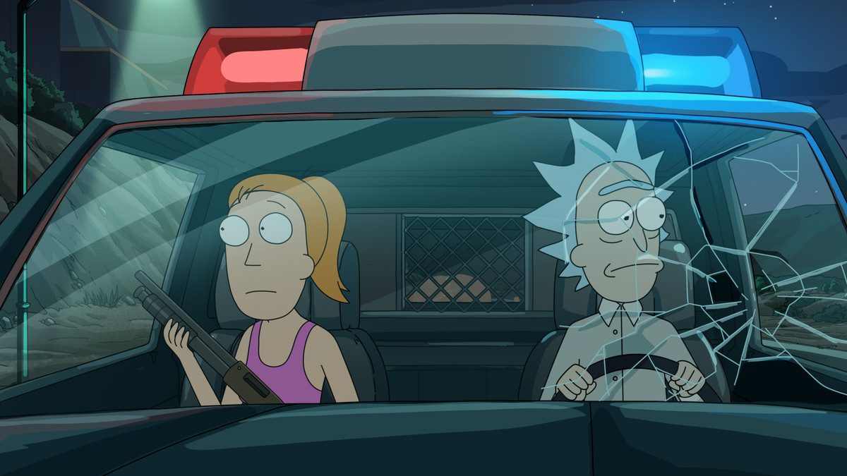 Summer et Rick assis dans une voiture de police avec la vitre avant tirée;  Rick regarde à sa gauche depuis le siège du conducteur, tandis que Summer tient un fusil de chasse et regarde à sa droite sur le siège du passager