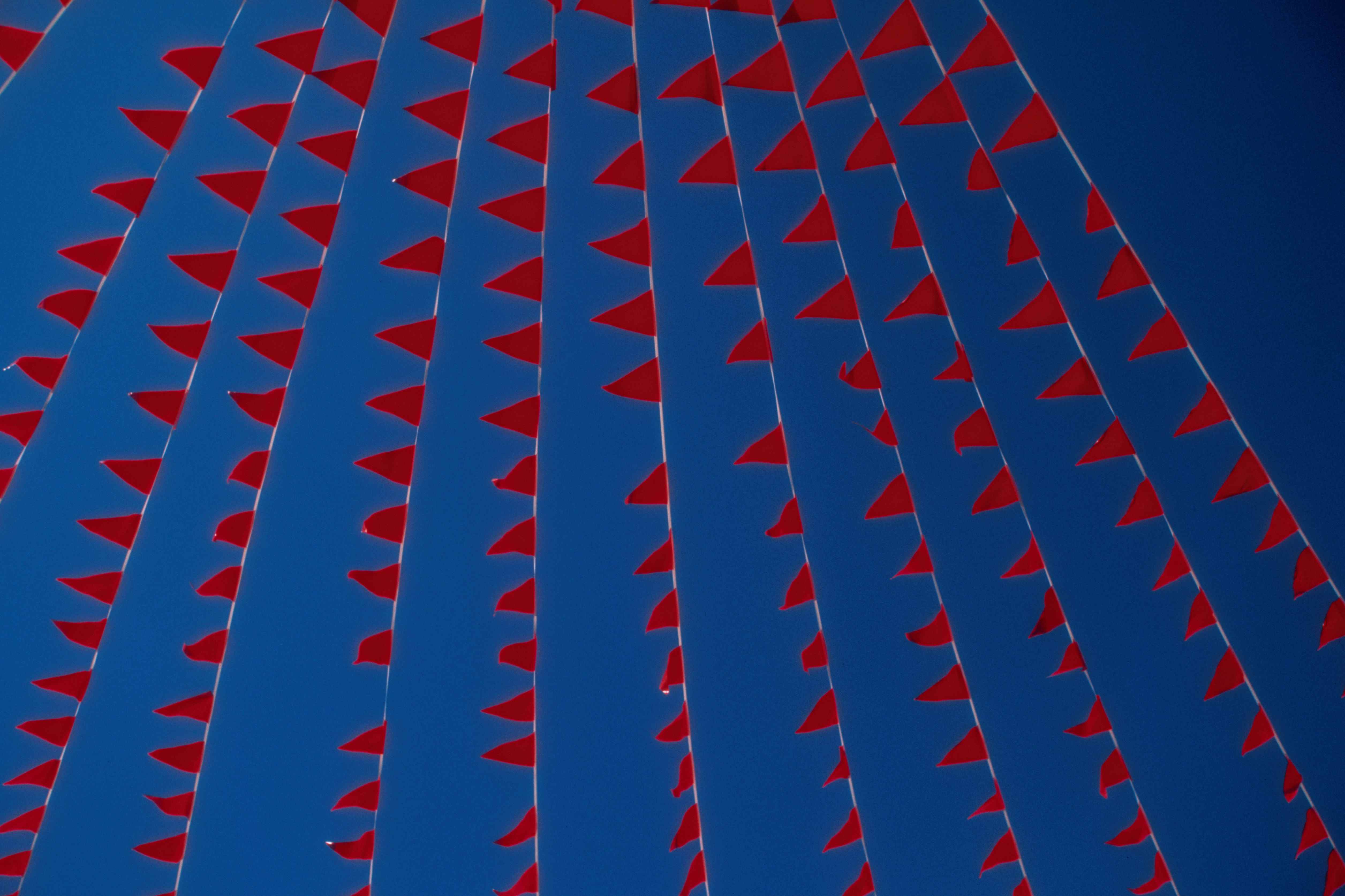 Image de drapeaux rouges contre un ciel bleu.