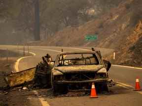 Les restes calcinés d'une voiture remorquant une remorque qui a brûlé lorsque le feu a sauté la rivière Klamath restent sur l'autoroute à l'incendie de McKinney dans la forêt nationale de Klamath au nord-ouest d'Yreka, en Californie, le 31 juillet 2022.