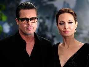 Angelina Jolie (R) pose pour des photos avec Brad Pitt à leur arrivée pour la première du film 