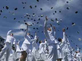 Les cadets de l'US Coast Guard Academy jettent leur chapeau en l'air à la fin des 141e exercices de lancement à l'US Coast Guard Academy le mercredi 18 mai 2022 à New London, Connecticut.