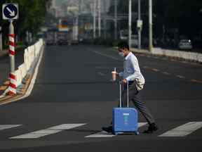 Un homme pousse ses bagages dans une rue de Pékin le 30 août 2022.