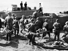 Des membres du Corps de santé royal canadien évacuent des soldats alliés de la plage après le raid de Dieppe, en France, pendant la Seconde Guerre mondiale.